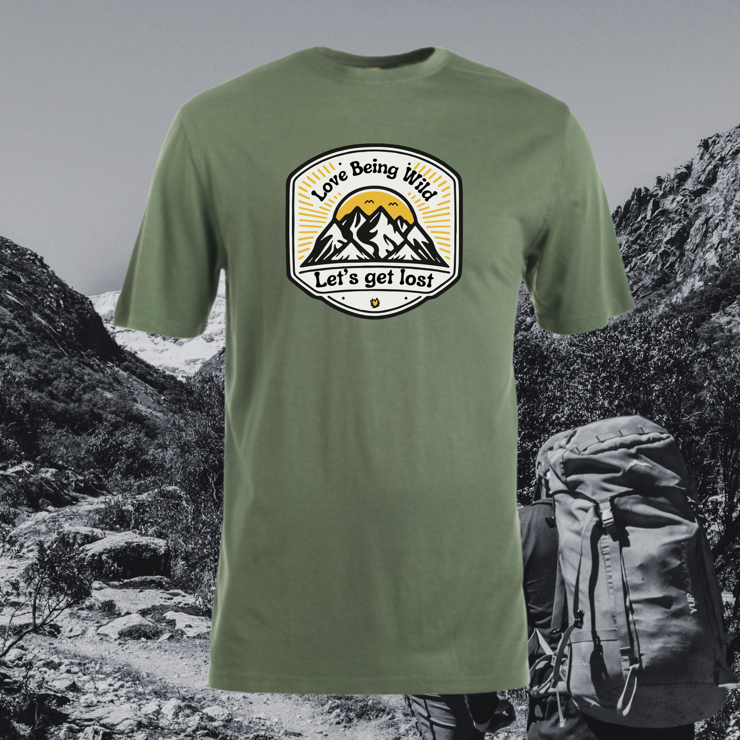 Green t-shirt with a mountain graphic and text 'Love being wild, let's get lost' against a mountainous background.