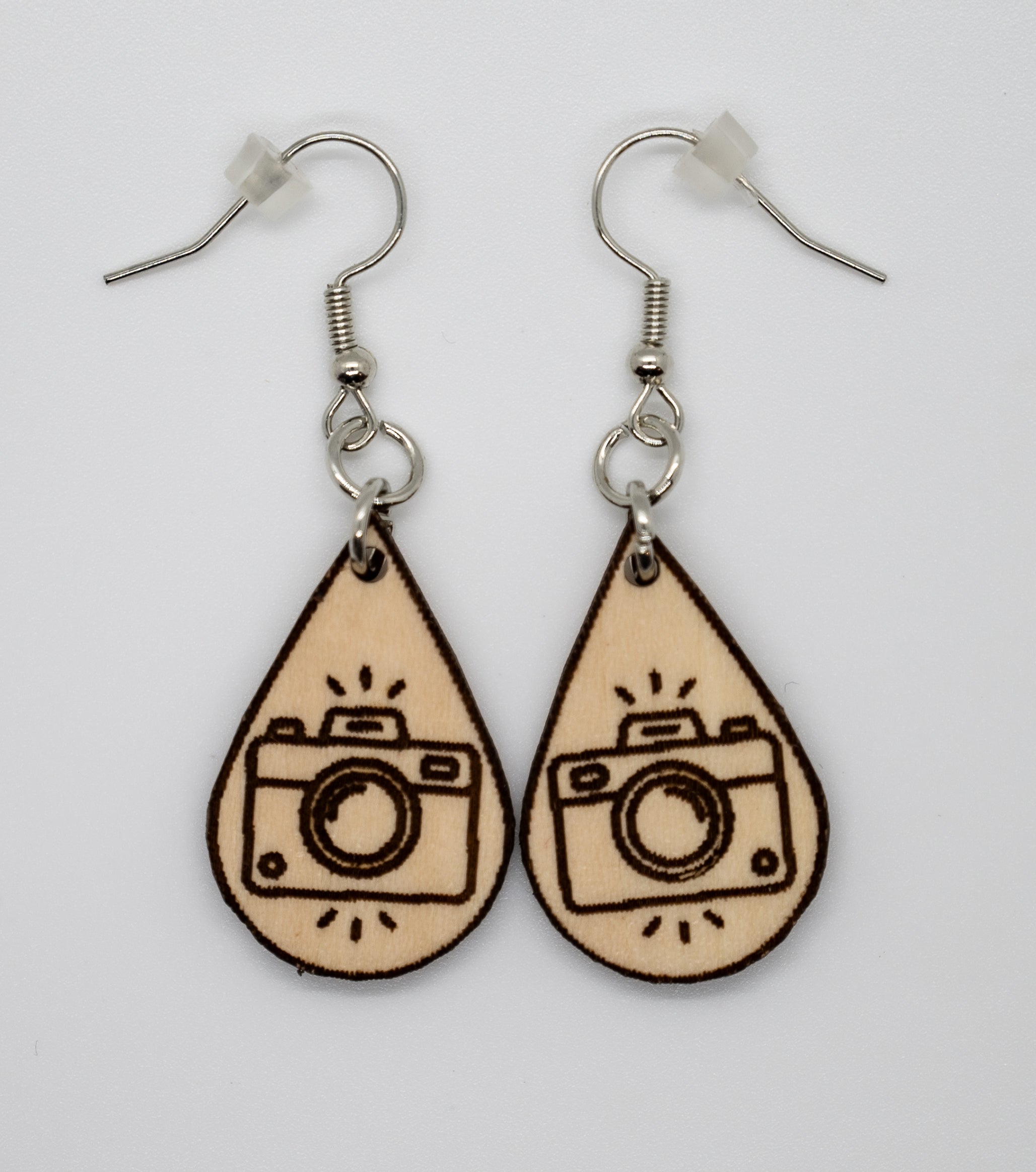 Teardrop-shaped earrings with camera design on a white background