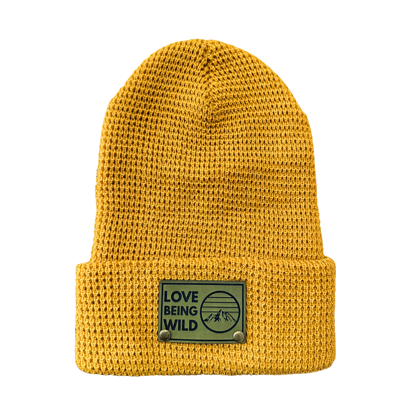 Yellow knit beanie with a patch that says 'Love Being Wild' on a white background