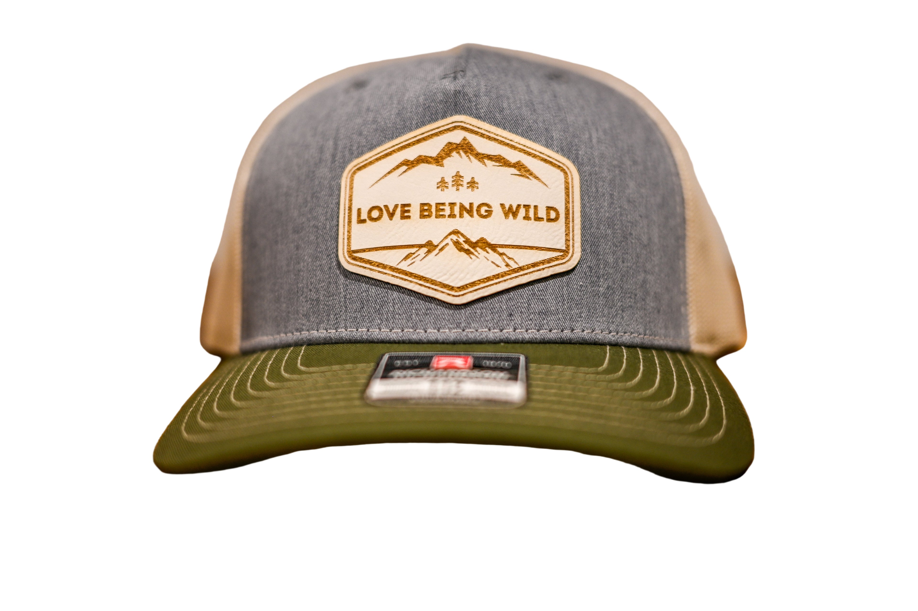 Gray and green cap with 'Love Being Wild' logo on a wooden surface