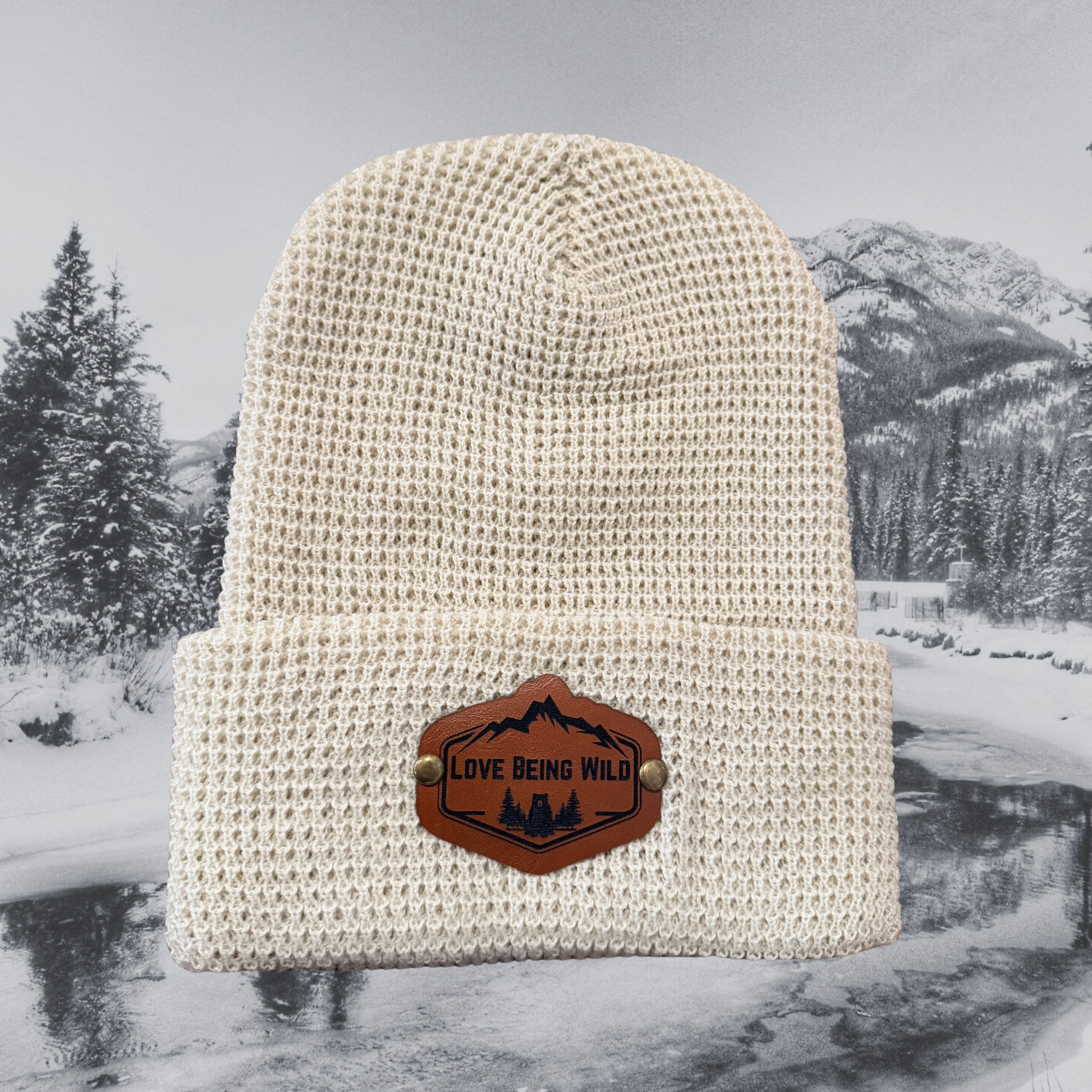 Beige knit beanie with a leather patch on a snowy landscape background