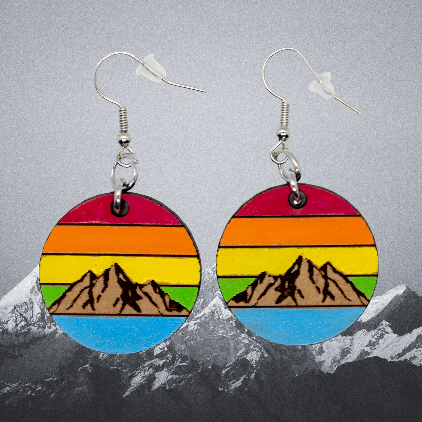 Colorful mountain-themed earrings with a gray background