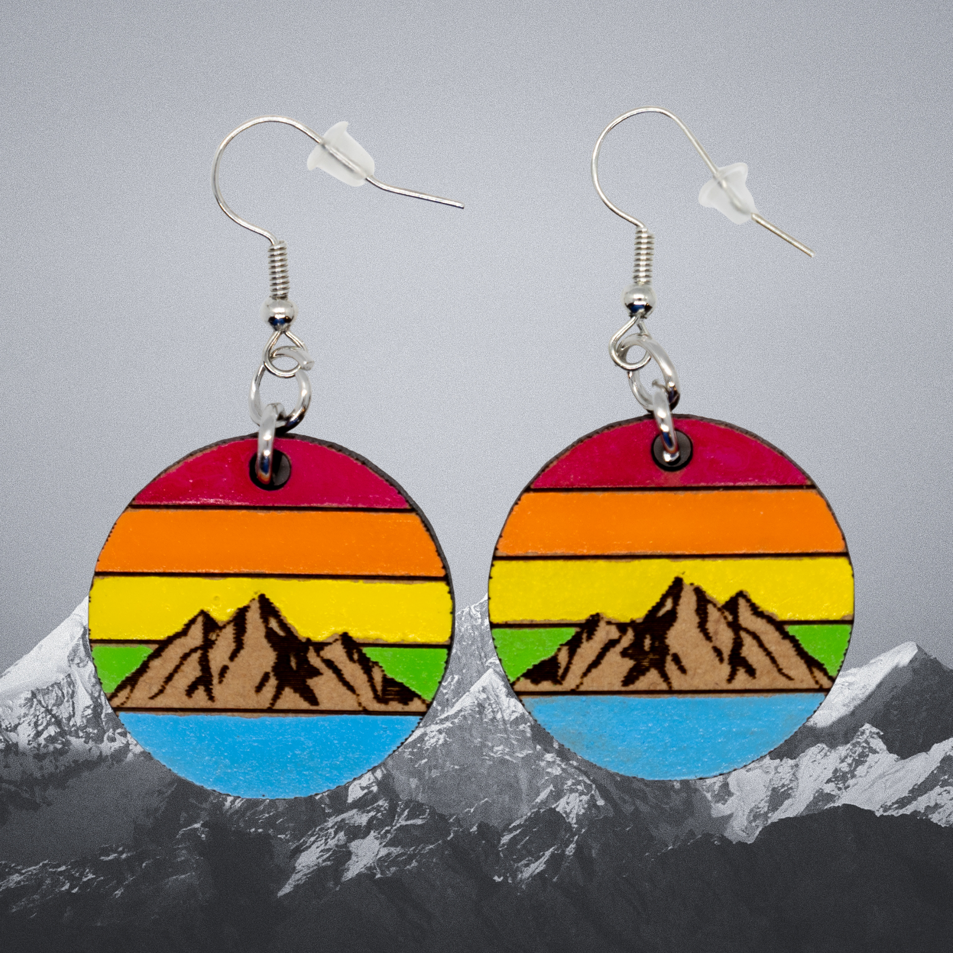 Colorful mountain-themed earrings with a gray background