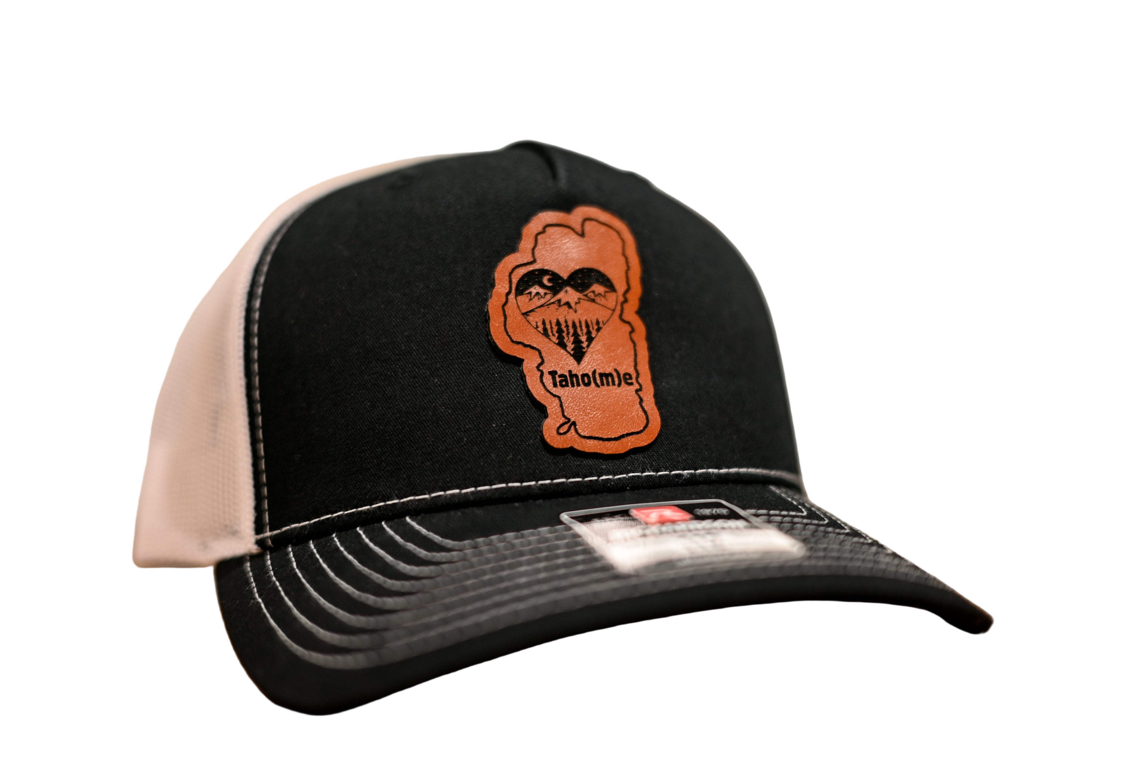 Black cap with Lake Tahoe shaped patch and the word Taho(m)e on it