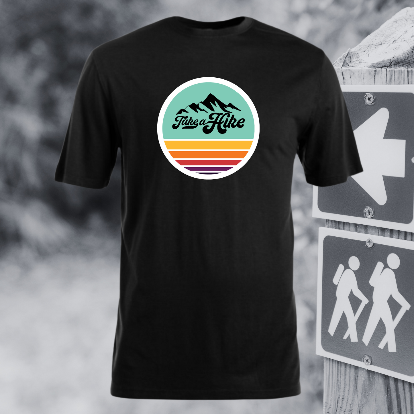 Black t-shirt with 'Take a Hike' graphic design in front of hiking signs.