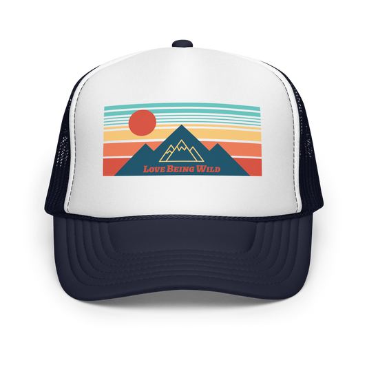 Trucker hat with mountain and sun design and 'Love Being Wild' text on a white background