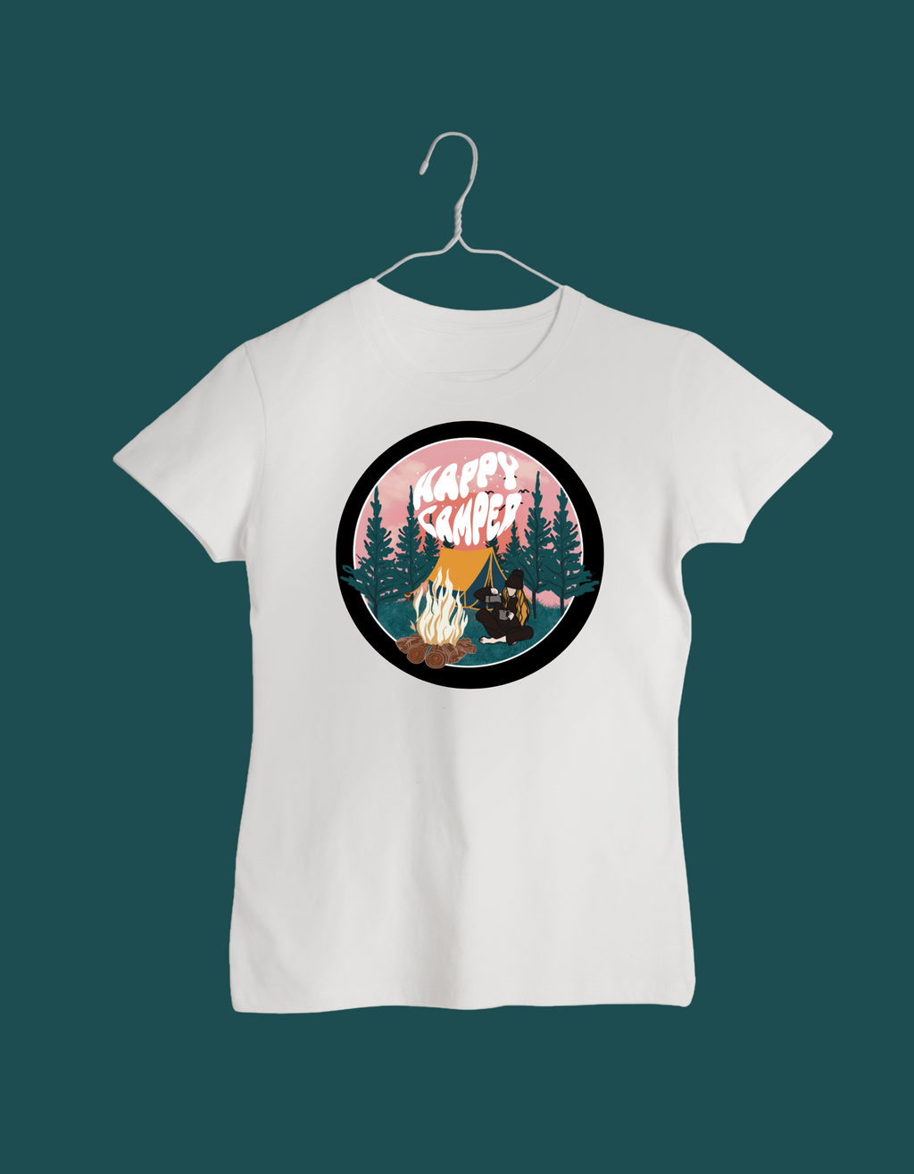 White t-shirt with 'Happy Camper' graphic on a hanger against a dark green background